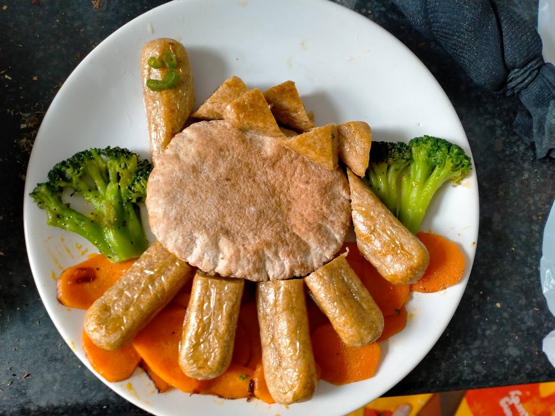 pitta, vegan sausages, broccoli and carrots in the shape of a dinosaur
